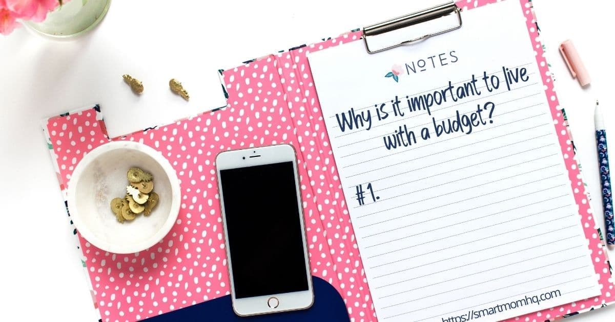 writing on clipboard says why is it important to live on a budget laying on pink placemat by iphone