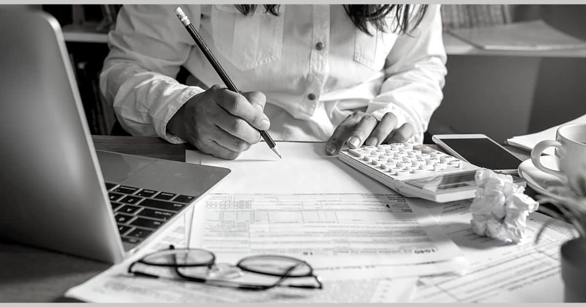 home page mom working on budget with ledger and calculator