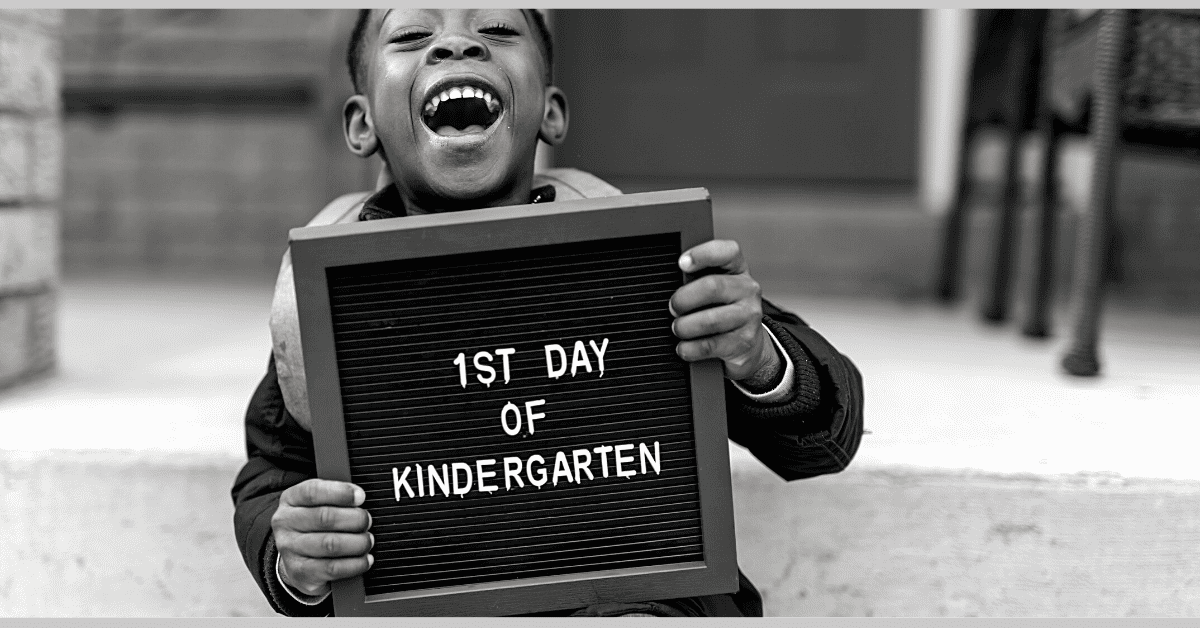 happy boy holding sign first day of kindergarten for activities by grade leve